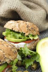 Sandwiches with avocado, camembert, vegetable salad and salami. Breakfast on the rustic table.