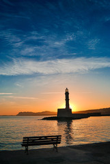 Sunrise view from the port of Chania Crete in Greece. Sun rises behind the lighthouse of the port