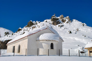 Winter scenery of a chapel covered with snow at mountain Ziria in Greece