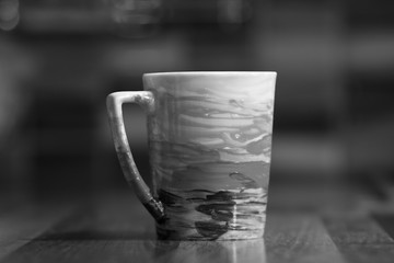 Hand painted colored mug on black and white abstract photo.