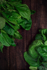 top view green raw spinach leaves with water drops on wooden background