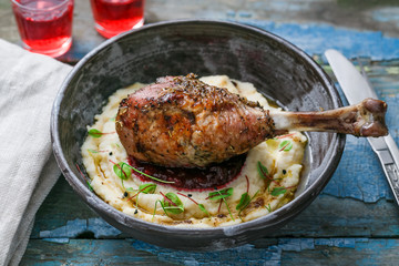 Dinner with baked turkey leg with cranberry sauce on mashed celery root