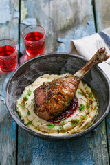 Dinner with baked turkey leg with cranberry sauce on mashed celery root