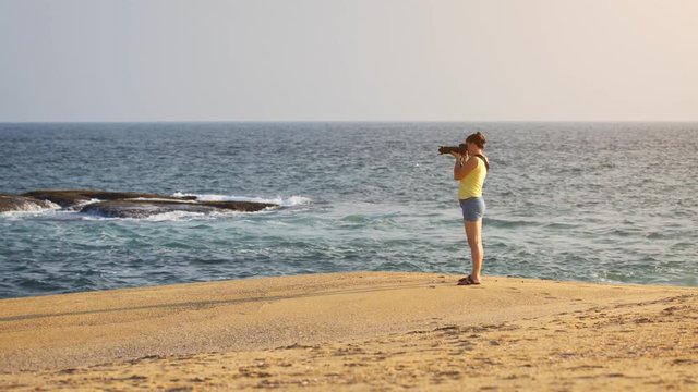 Woman Photographing Sri Lankan Oceanscape from Sandy Beach