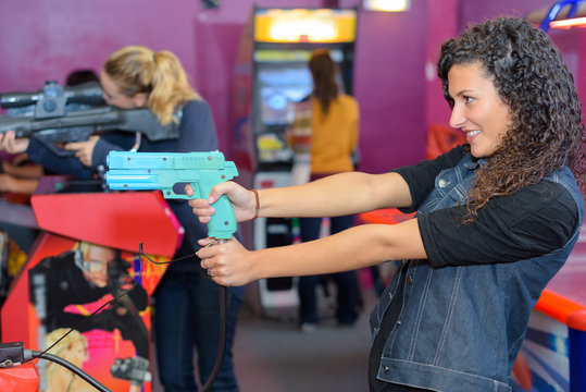 Woman firing gun on arcade game