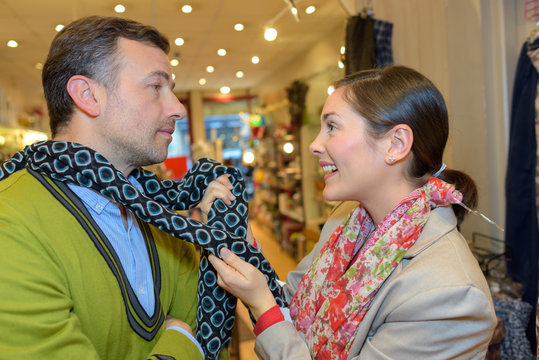 young couple is chossing scarfs together