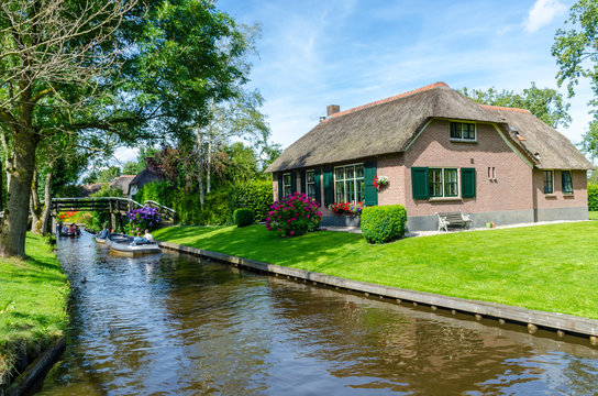 Giethoorn, Netherlands: View of famous Giethoorn village with canals and rustic thatched roof houses.The beautiful houses and gardening city is know as "Venice of the North"