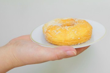 Hand Holding Delicious Glazed Donut with Sugar