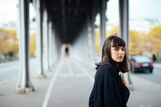 Fototapeta Female beauty concept. Portrait of fashionable young girl in casual black jacket posing on the street.