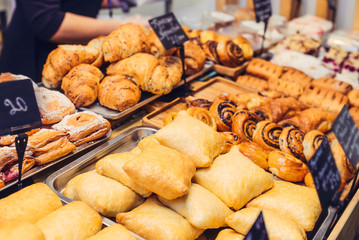 Close up freshly baked pastry goods on display in bakery shop. Selective focus