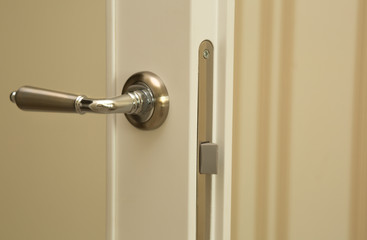 Closeup shot of beige partition door handle. Empty space