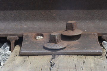 Close-up of railroad rail with highlight for bolts and sleepers