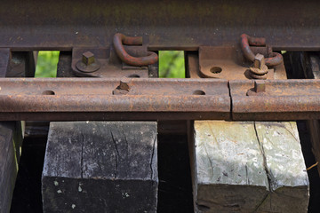Close-up of railroad rail with highlight for bolts and sleepers