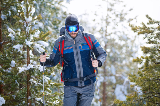 Sportsman hiking in winter with snow thru wood