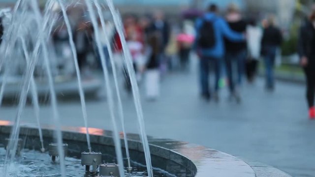 City center with walking people and fountain. Background with cityscape