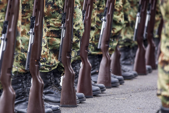 Soldiers stand in row. Gun in hand. Army, Military Boots lines of commando soldiers in camouflage uniforms