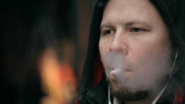 Closeup shot of a man's face who smoking a cigarette.