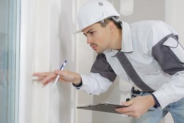 young builderchecking a wall in a construction site