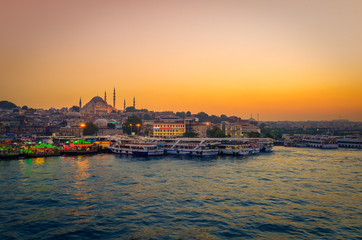Istanbul, view from Galata bridge, with mosque and boats at sunset, Turkey 