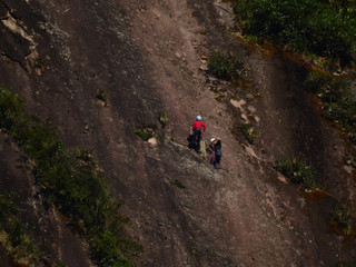 couple of climbing climbers climbing a sea wall in a big mountain