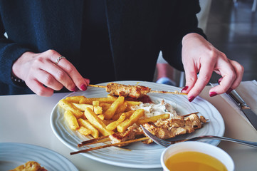 Woman eating meat with fries