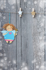 Little christmas fairy with a little clothespins in form of star hanging on the rope.
