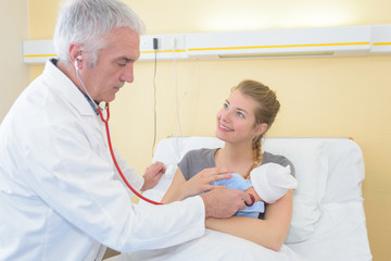 Obraz premium mother holding baby for pediatrician to examine