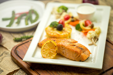 Grilled Salmon with garlic and herb ,lemon isolated on white plate