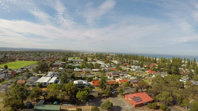 Drone footage panning from suburban house rooftops to sea and coastline, taken at Henley Beach, South Australia.