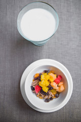Smoothie bowl topped with currant, cantaloupe, jelly, corn flake and milk.