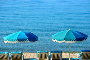 Luxury tropical caribbean beach resort sunbathing umbrella and lounger chair on sand deep blue sea photo