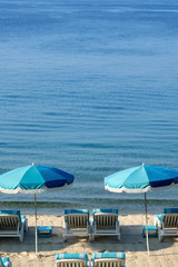 Luxury tropical caribbean beach resort sunbathing umbrella and lounger chair on sand deep blue sea photo vertical