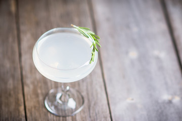 Tasty cocktail with rosemary on the rustic background. Shallow depth of field. Selective focus.