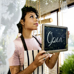 Woman Hanging Open Sign by the Glass Window