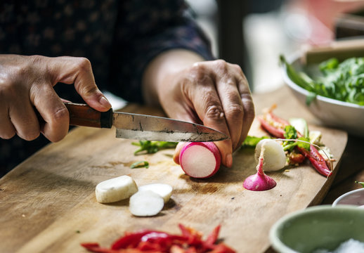 Hands using a knife chopping turnips
