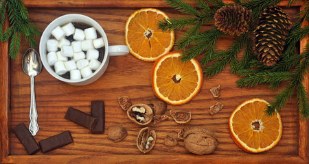 Coffee with marshmallow, chocolate and christmas fir branches on a wooden tray. View from above. Christmas and New Year. Still life