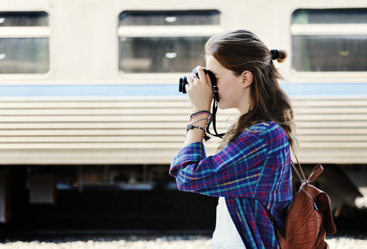 Young woman is taking photo with film camera