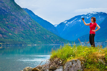 Tourist taking photo at norwegian fjord