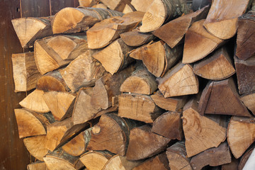 Fototapeta premium Woodpile of chopped lumber. Pile of wood logs. Stacked firewood timber