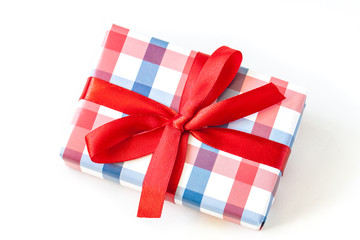 Gifts box in wrapping paper tied with red bow. Festive packaging mock up 