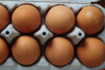 Fresh brown eggs with yolk on cardboard tray