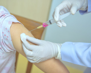Soft focus nurses are vaccinations to patients using the syringe.Doctor vaccinating women in...