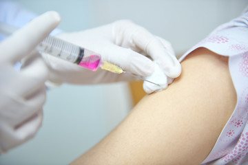 Soft focus nurses are vaccinations to patients using the syringe.Doctor vaccinating women in hospital.Are treated by the use of sterile injectable upper arm. injection