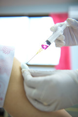 Soft focus nurses are vaccinations to patients using the syringe.Doctor vaccinating women in...