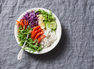 Smoked salmon, rice, vegetables buddha power bowl on gray background, top view. Red cabbage,...