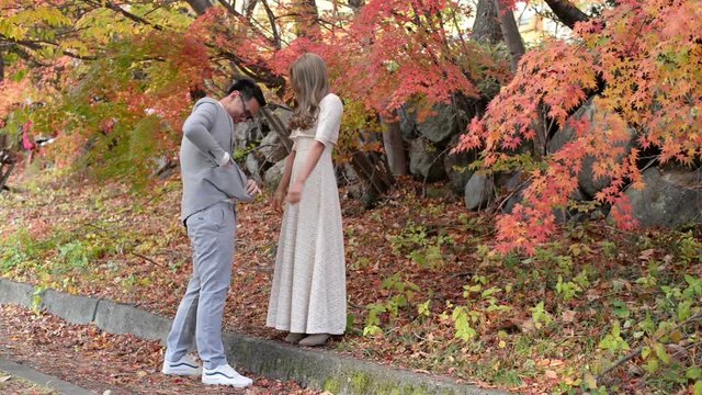 Romantic marriage proposal in the red maple autumn scene