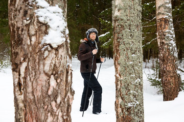 Young man cross-country skiing in the forest 