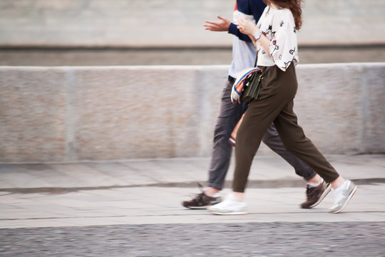 a guy and a girl are walking around the summer city, walking fast and in step