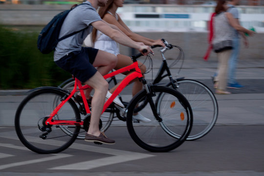 a girl and a guy spend time together riding on bicycles in the summer evening city