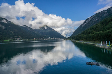 Fototapeta na wymiar Beautiful landscape Achensee lake, alpine mountains, blue sky and clouds, reflections in water. Tirol, Austria.